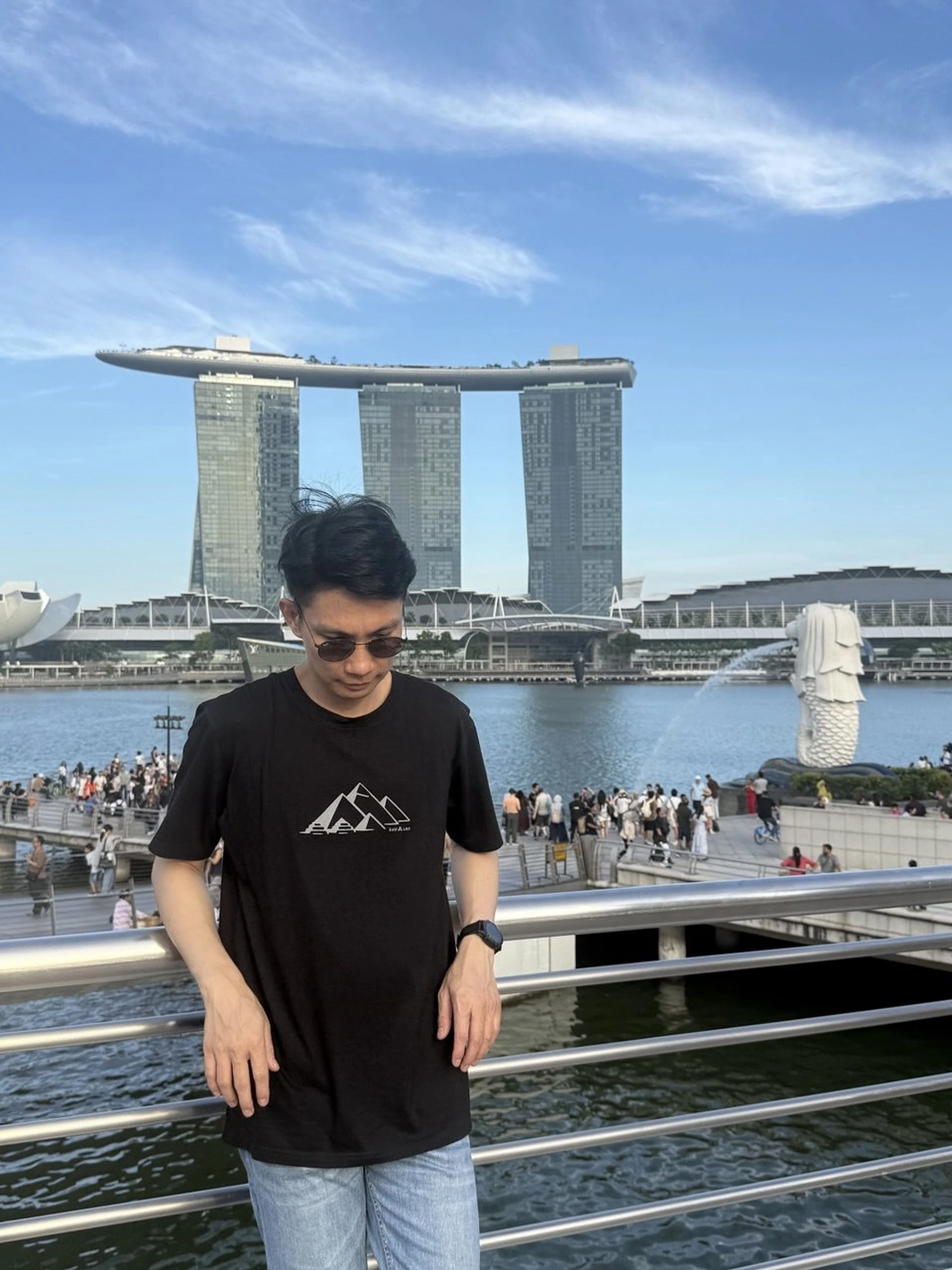นักเดินทางสวมเสื้อ RAW A LINE สีดำบริเวณริมน้ำในเมือง